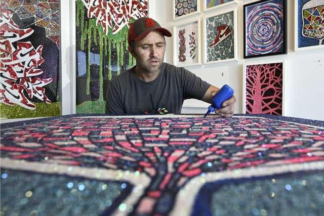 Dylan Mortimer works on a painting in his Long Beach studio.