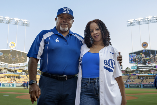 皇冠hga025大学洛杉矶分校健康 nurse Lakeysha Pack with Rudy Lopez, the umpire whose life she saved using CPR, pose together on the field at Dodger Stadium.