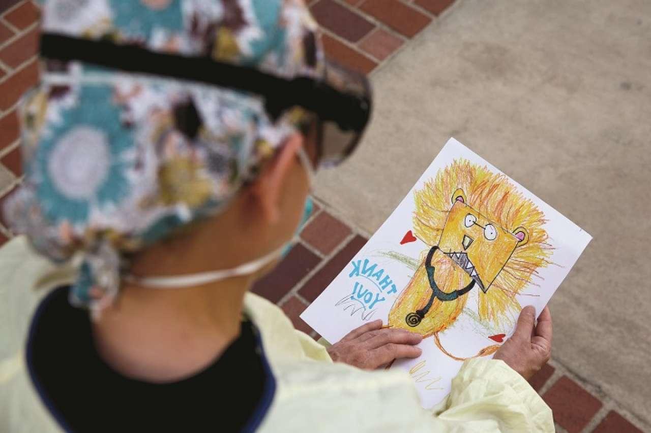 Physician holding Thank You card